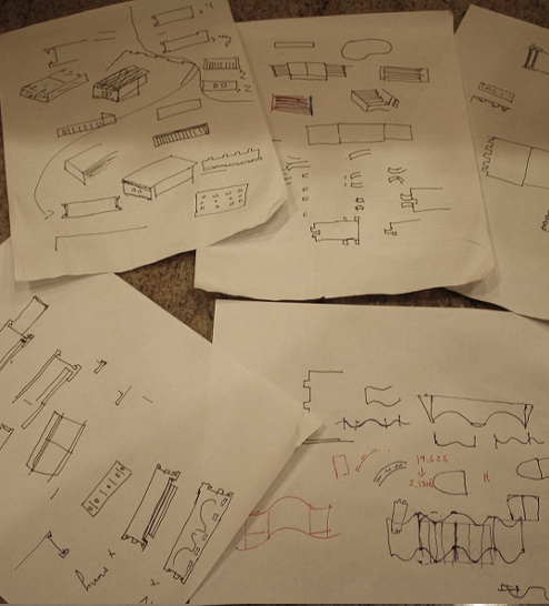 several sheets of paper with drawn designs and components.