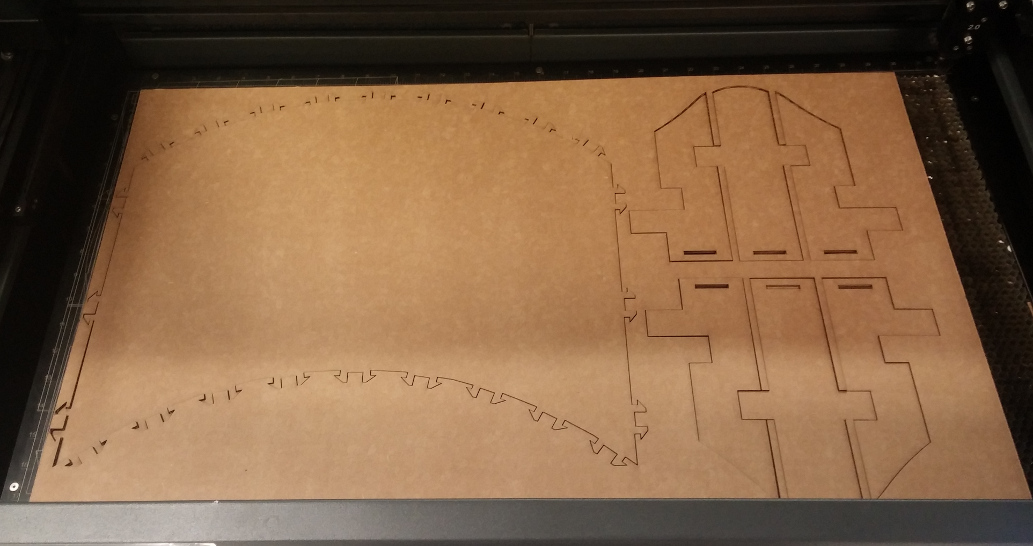 Top of desk and 6 panels inscribed in sheet in laser cutter bed.