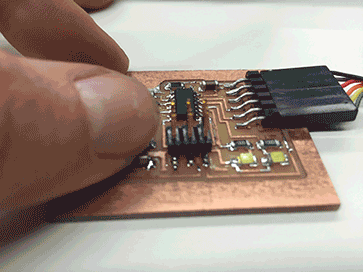 Close up of a thumb pressing circuit board and triggering an LED light on and off