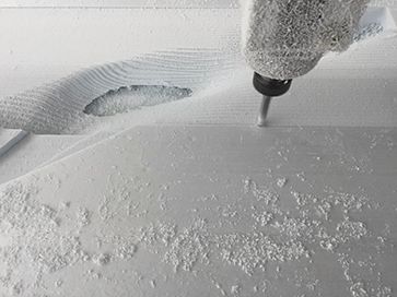 Light blue foam being milled by a CNC machine