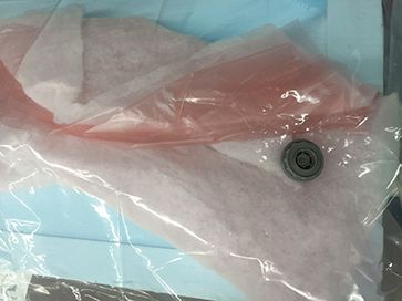 Light blue foam and pink sheets of plastic inside a vacuum bag