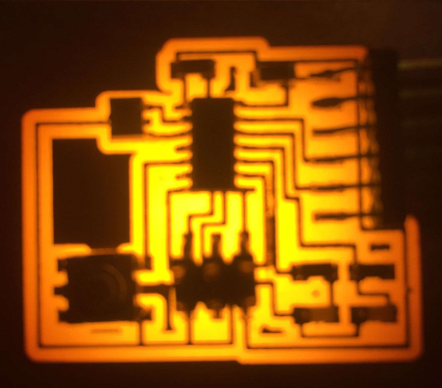 Dark circuit board image with traces lit up in orange