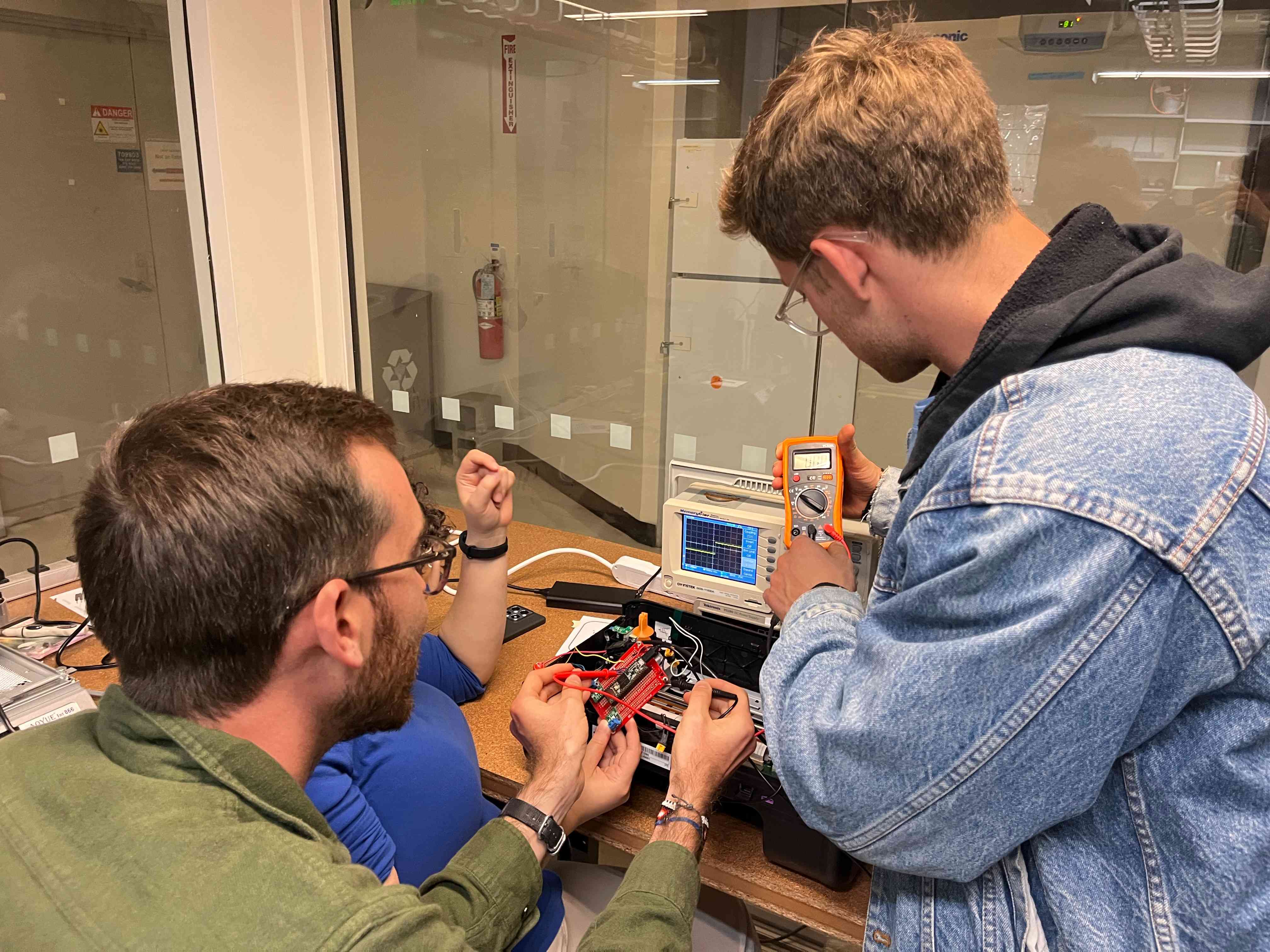 Ben and Ceci showing Tyler how to measure current with the multimeter.