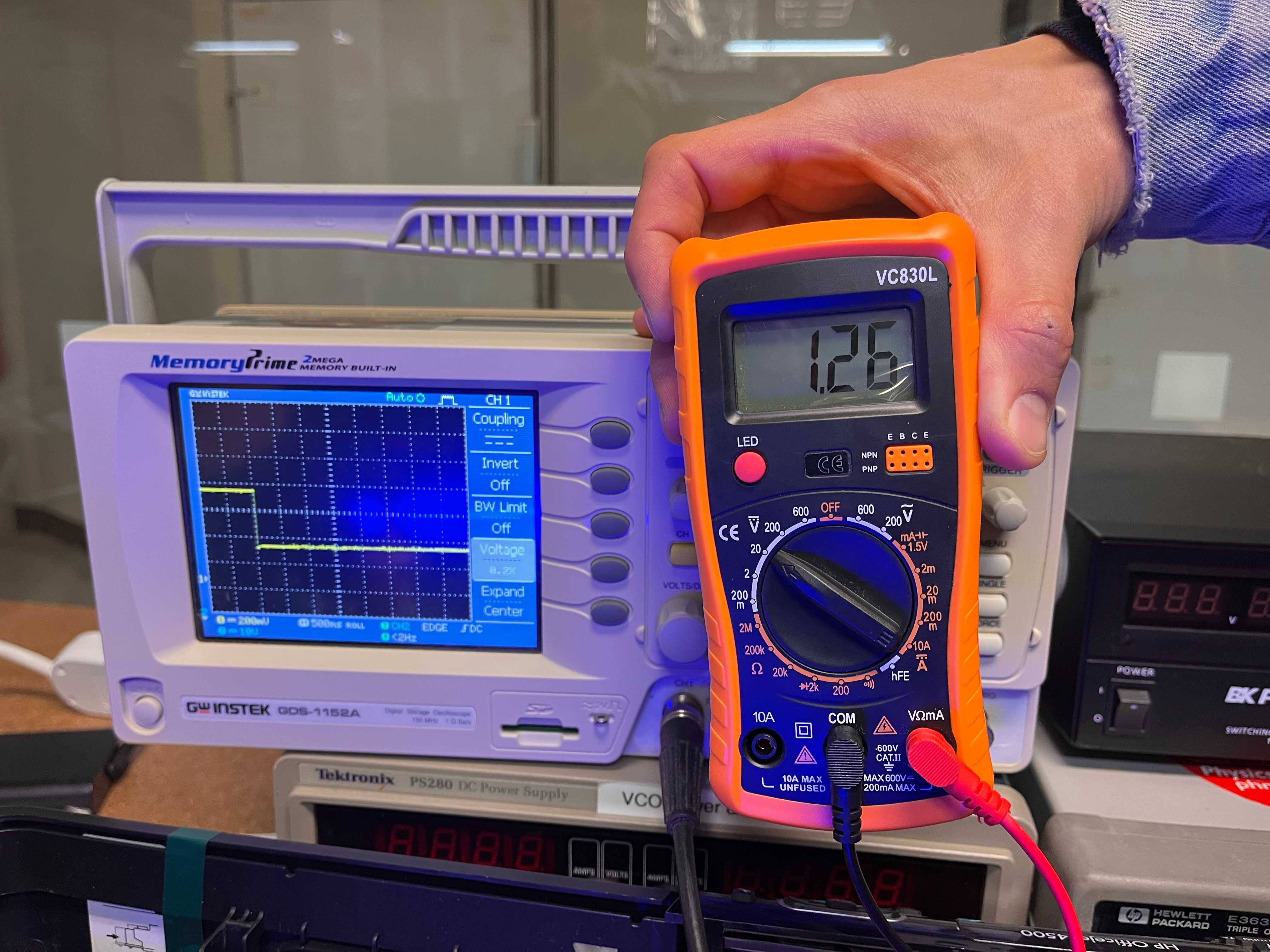 A close-up of the multimeter and oscilloscope. We compared these measurements to compare the signals across different instruments.