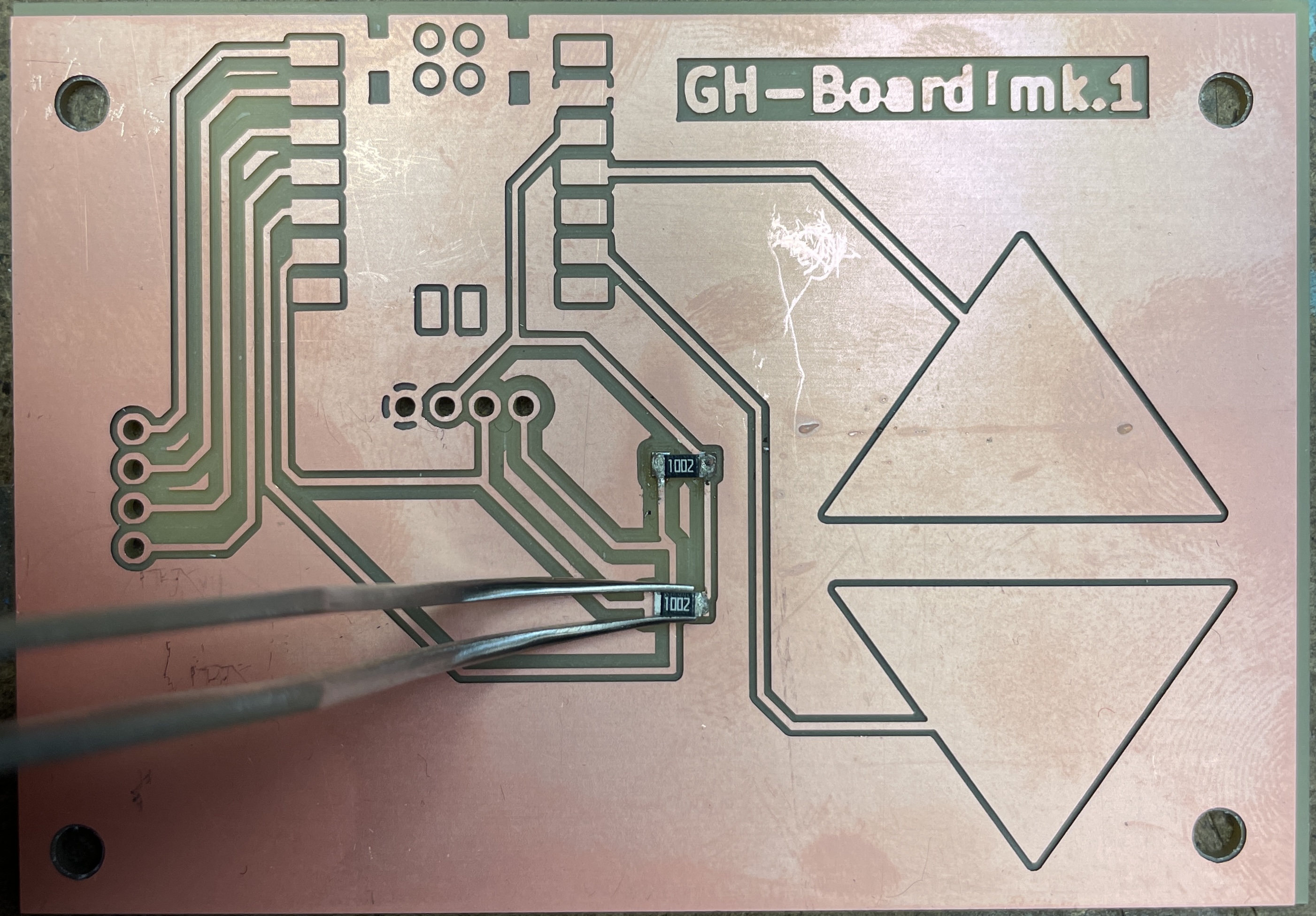 Placing the resistor down with tweezers and soldering one side