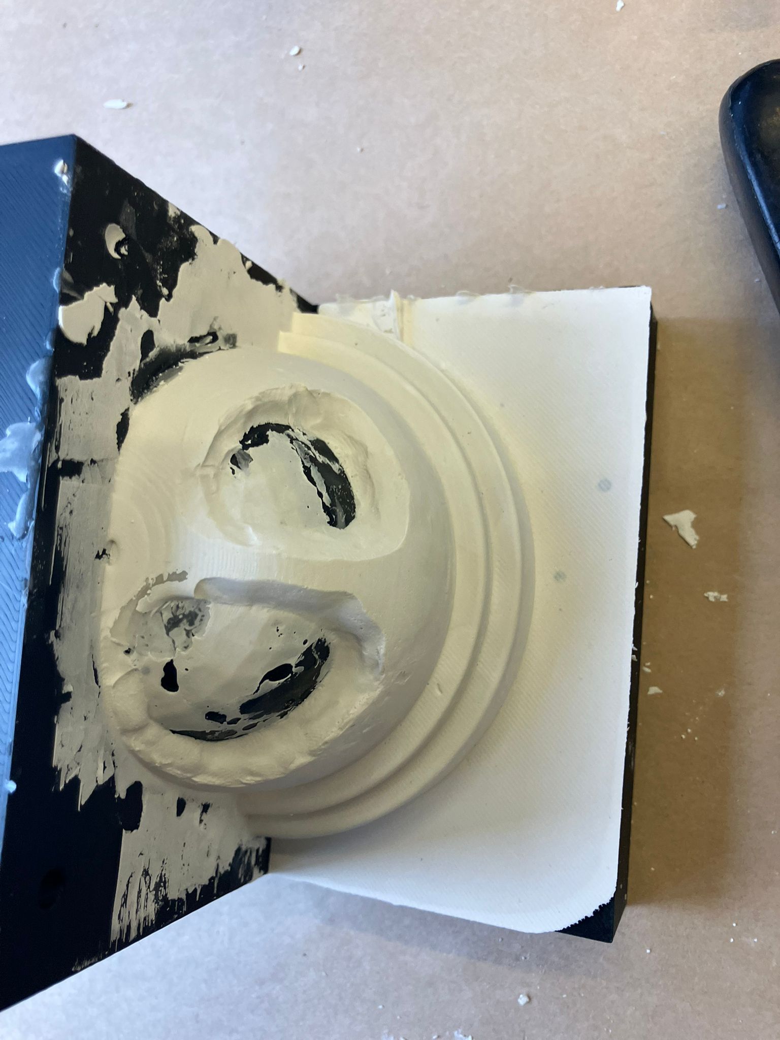 Putty knife tracing the seam on the topology optimized dome mold